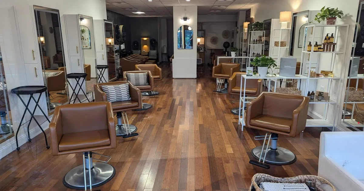 Intérieur lumineux d'un salon de coiffure avec fauteuils en cuir et parquet en bois